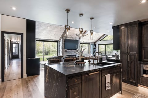 - Entertain with ease in a chef's kitchen open to living space  
- Prep meals on the marble island with ample seating  
- Enjoy open flow design leading to stone fireplace and yard views