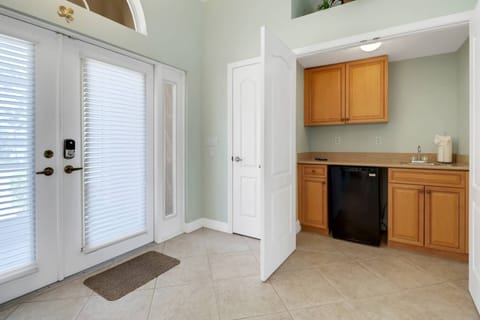 A wet bar with mini fridge is located close to the main living area, near the front entrance.