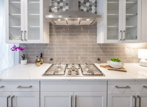 The space features state-of-the-art equipment, including a professional-grade gas cook-top, double ovens, and a large refrigerator.