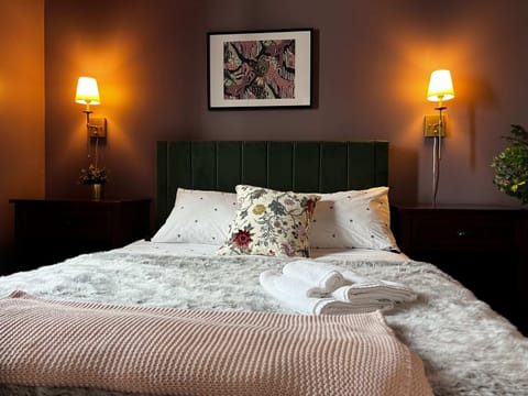 Relax in a queen bed with stylish lighting and handy drawer space
