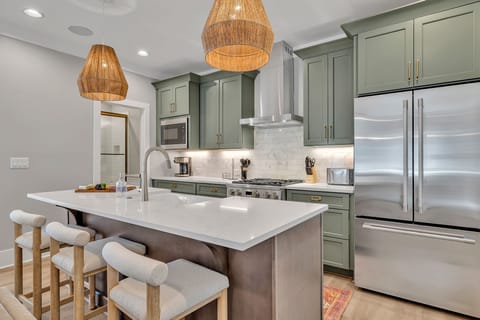 Unit 1 - 2nd Floor: Fully equipped kitchen stocked with all culinary essentials featuring stainless-steel appliances and a kitchen island offering ample counter space and bar seating.