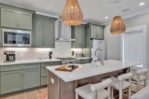 Unit 1 - 2nd Floor: Fully equipped kitchen stocked with all culinary essentials featuring stainless-steel appliances and a kitchen island offering ample counter space and bar seating.