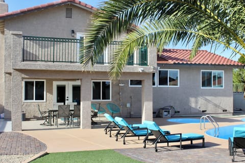 Balcony overlooking pool and spa with patio furniture underneath.