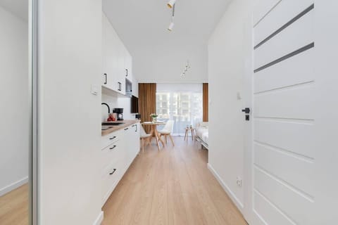 Hallway with minimalist decor, light-colored walls, and wooden flooring, giving the space a cozy and modern feel.