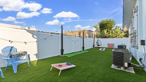 Enjoy the Cocoa Beach backyard featuring classic Adirondack seating, a fun putting green, and a snug egg chair designed for effortless outdoor comfort.