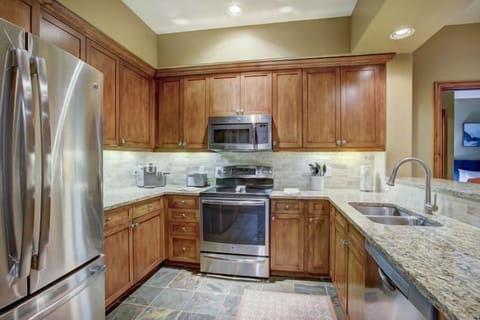 The gourmet kitchen showcases elegant wooden cabinetry, modern stainless steel appliances, and granite countertops, perfect for culinary adventures.