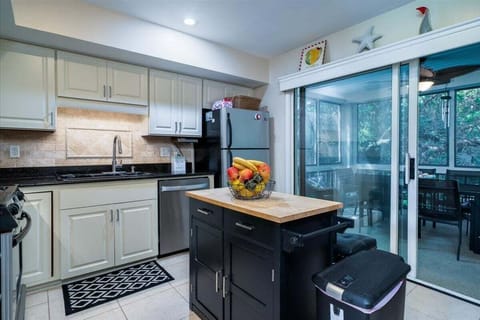 A center island has stools.  Sliding door off the kitchen leads out to the screen porch