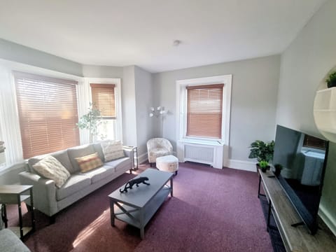 The living room comes furnished with essential pieces, including a comfortable sofa, a coffee table, and a TV, providing immediate comfort upon move-in.
