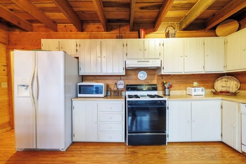 Fully equipped kitchen with a gas stove and oven, fridge with ice and water dispenser, countertop microwave, and toaster.