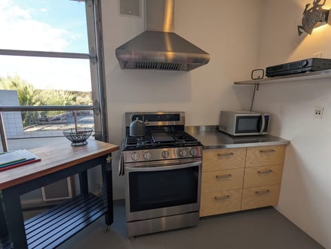 full kitchen: gas stove and oven, drawers, microwave, kitchen island