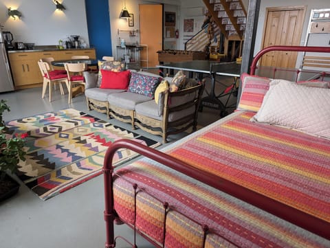 main room: queen bed for lounging, sofa, kitchen, ping-pong, fussball, stairs