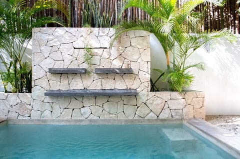 Dine in elegance with a stunning poolside view from our luxurious Tulum villa dining hall—a perfect blend of indoor comfort and outdoor beauty