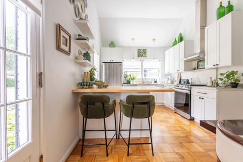 Airy kitchen with butcher block island. Seating for two.