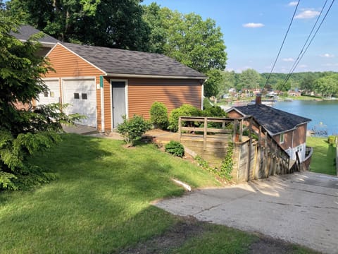 Garage, house and lake in background. Driveway for parking is behind the tree.