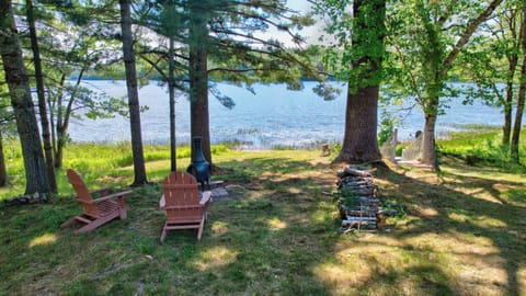 Chimnea and chairs facing the lake behind the log cabin