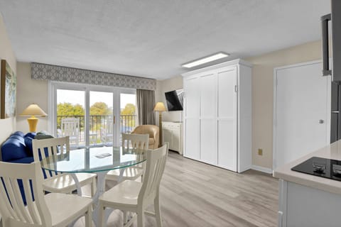 Relax in your bright, open-concept space featuring a glass dining table, cozy seating, and stunning balcony views that invite natural light throughout.