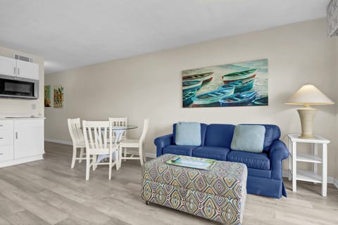 Unwind in your bright, coastal-themed living space with comfortable seating and convenient kitchenette for memorable vacation moments.