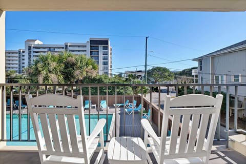 Relax on your private balcony with pool views and comfortable seating, perfect for morning coffee or evening unwinding.