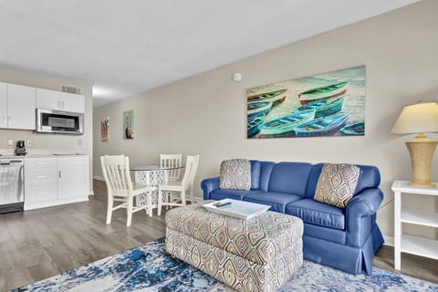 Sink into your plush blue sofa and enjoy coastal artwork while your open kitchen awaits morning coffee brewing.