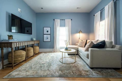 When you enter the property, you will be greeted by this calming, serene living room. There is a plush sectional sofa, a smart tv, and extra poof seating.