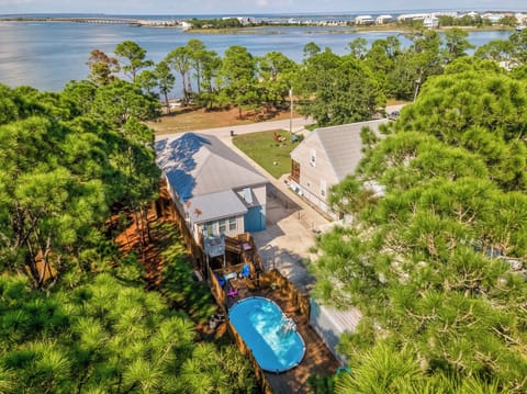 Coastal property featuring swimming pool and waterfront location surrounded by lush greenery.