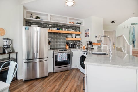 Well appointed kitchen includes electric oven and cooktop, and combination washer and dryer. 