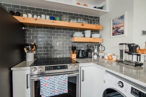 Kitchen includes pots, pans, place settings, and utensils needed for basic meal prep 