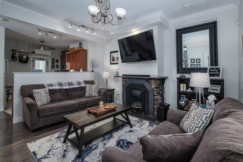Grade level living room with new sofa set, fully equipped kitchen, and dining area.