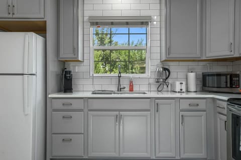 **Bright and Modern Kitchen**  Our bright and modern kitchen is fully equipped for all your culinary needs. With sleek appliances and a large window offering natural light, it’s perfect for preparing meals and enjoying your stay. Book now to experience co