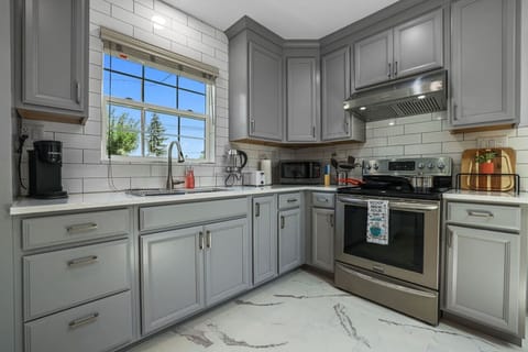 **Modern and Fully-Equipped Kitchen**  Step into our modern kitchen, complete with all the essentials you need for a comfortable stay. Featuring sleek appliances, ample counter space, and a large window for natural light, it`s perfect for cooking meals or