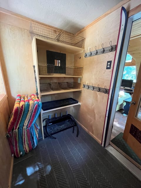 Entryway with boot warmer, bins, and coat hooks