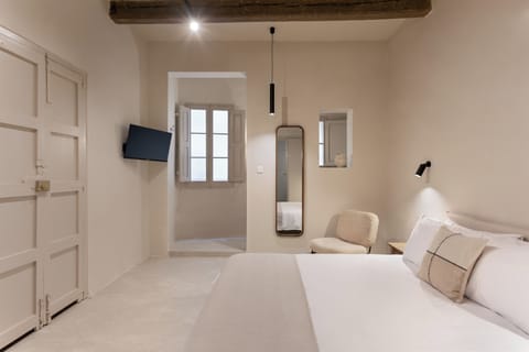 Bedroom with TV and windows overlooking the alley