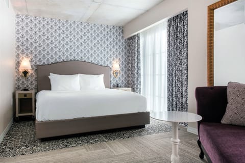 Unwind in crisp linens beside tall windows and soft light.