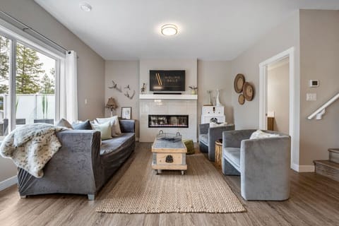 Living room with an electric fireplace, smart TV & cozy seating on the main level of Woodland Hooves.
