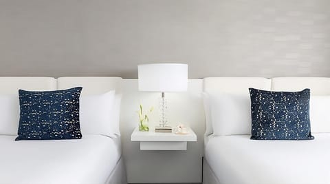 Sink into hotel-soft pillows under warm, restful bedside lighting.