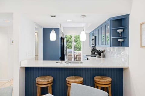Bar stools sit at the counter between the dining area and the kitchen