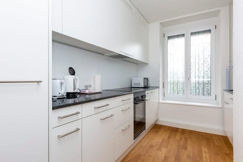 Bright and spacious kitchen, fully equipped with V-Zug kitchen appliances - electric stove, oven, refrigerator, dishwasher and a washing machine/dryer from Electrolux.