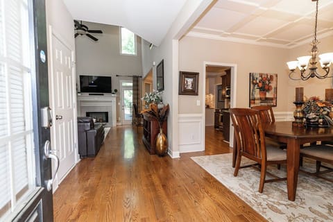 Bright and welcoming foyer opens into a spacious floor plan with the dining room to the right and the living room and kitchen straight ahead—perfect for easy flow and connection throughout the home.