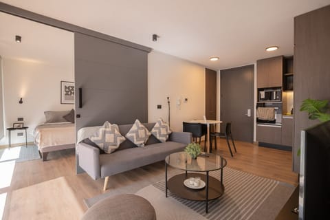 Modern open-plan living with cozy seating and sleek kitchen, perfect for a comfortable stay.