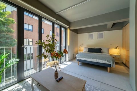 Relax in this sunlit bedroom with modern decor and a cozy ambiance, perfect for unwinding after a day of exploring.