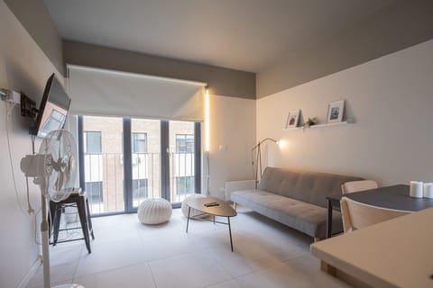 Bright and modern living room with sleek furnishings and ample natural light, perfect for relaxation and entertainment.