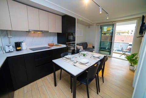 Chic and modern kitchen with a cozy dining area, perfect for intimate meals. Enjoy the seamless indoor-outdoor flow to the balcony.