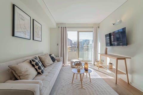 Relax in this stylish living room with a stunning city view and modern decor, perfect for unwinding after a day of exploring.