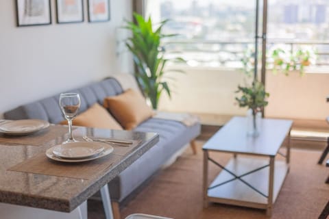 Bright and cozy living area with a stunning city view from the balcony, perfect for relaxation.