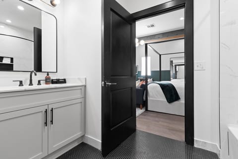 The studio bathroom offers sleek finishes, a soaking tub with Smart TV, walk-in shower, and plush towels. Spacious and private, it adds a luxurious touch to your suite—perfect for unwinding after a day in Downtown New Orleans.