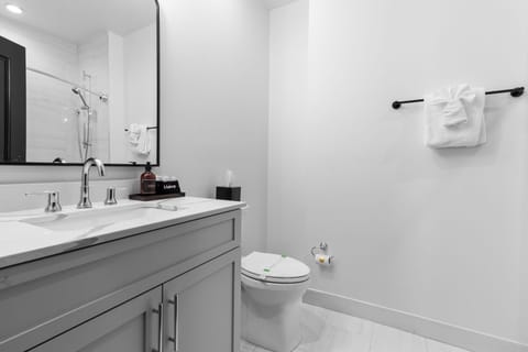 The guest bathroom includes fresh towels, a hairdryer, and complimentary toiletries. Conveniently located near the living area, it's stylish and practical—perfect for guests, families, or sharing during group stays at 888 Baronne.