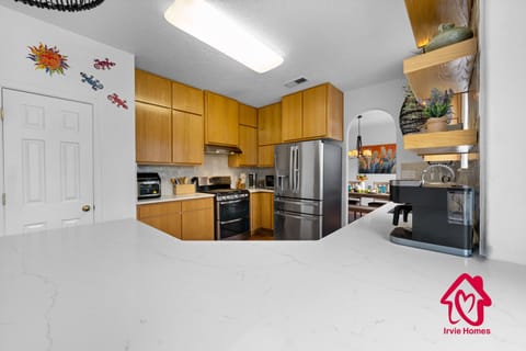 Modern kitchen with stainless steel appliances and wood cabinetry.