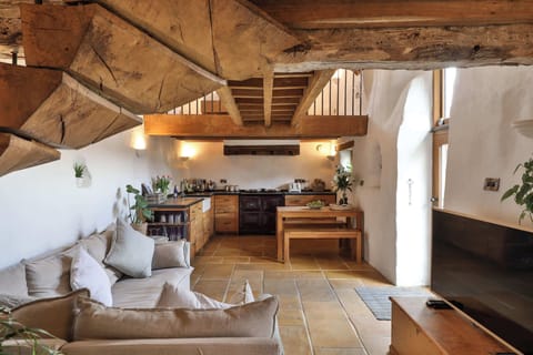 Stylish open-plan living area with exposed beams and original stonework – blending rustic charm with modern comfort.