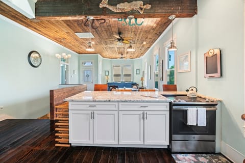 View of the living room from the kitchen with a peak of the stairs leading to the living area downstairs.