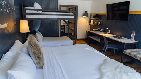 Recharge after adventures with comfy bedding and a handy workspace.